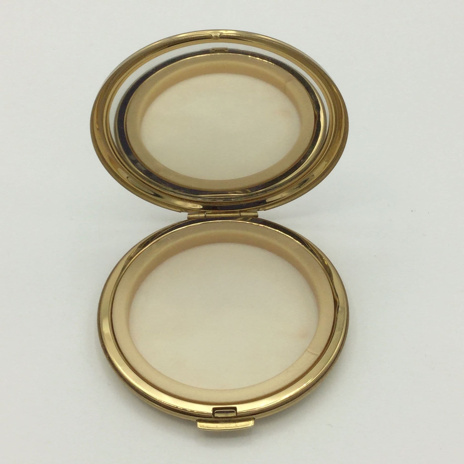 open Stratton compact showing a clear mirror and unsued powder screen