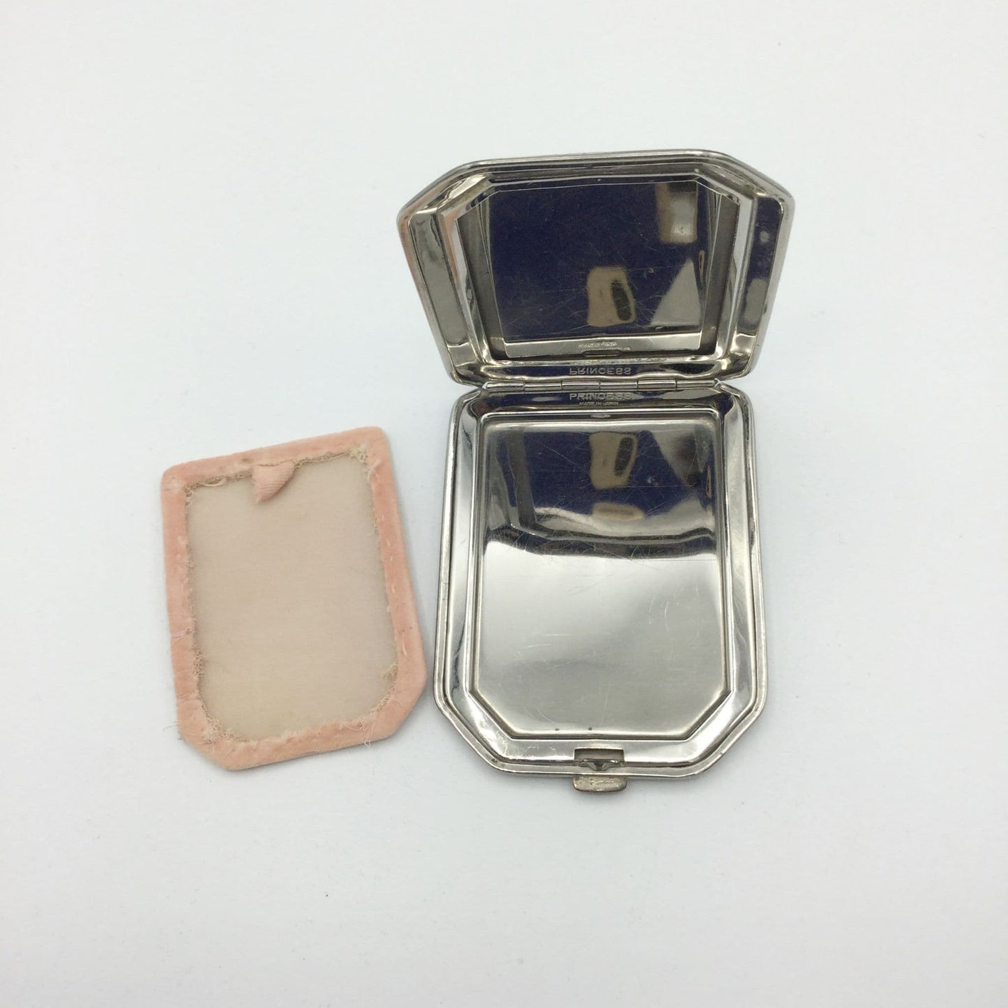 very reflective mirror of the art deco compact with the powder screen to one side