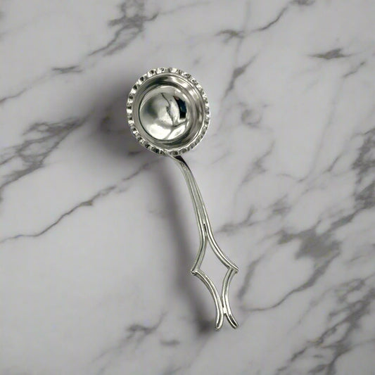 small silver plated ladle on a marble surface