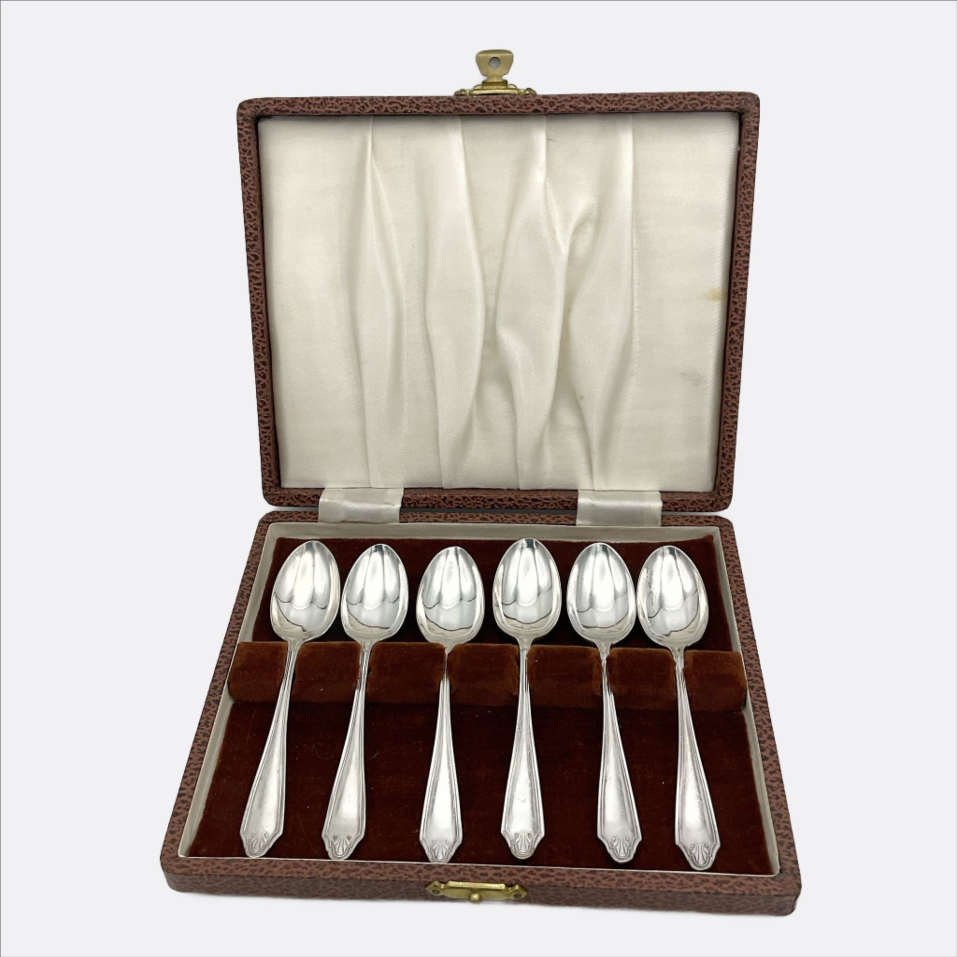 Six matching silver plated coffee spoons in a brown presentation box with a brown and cream interior.
