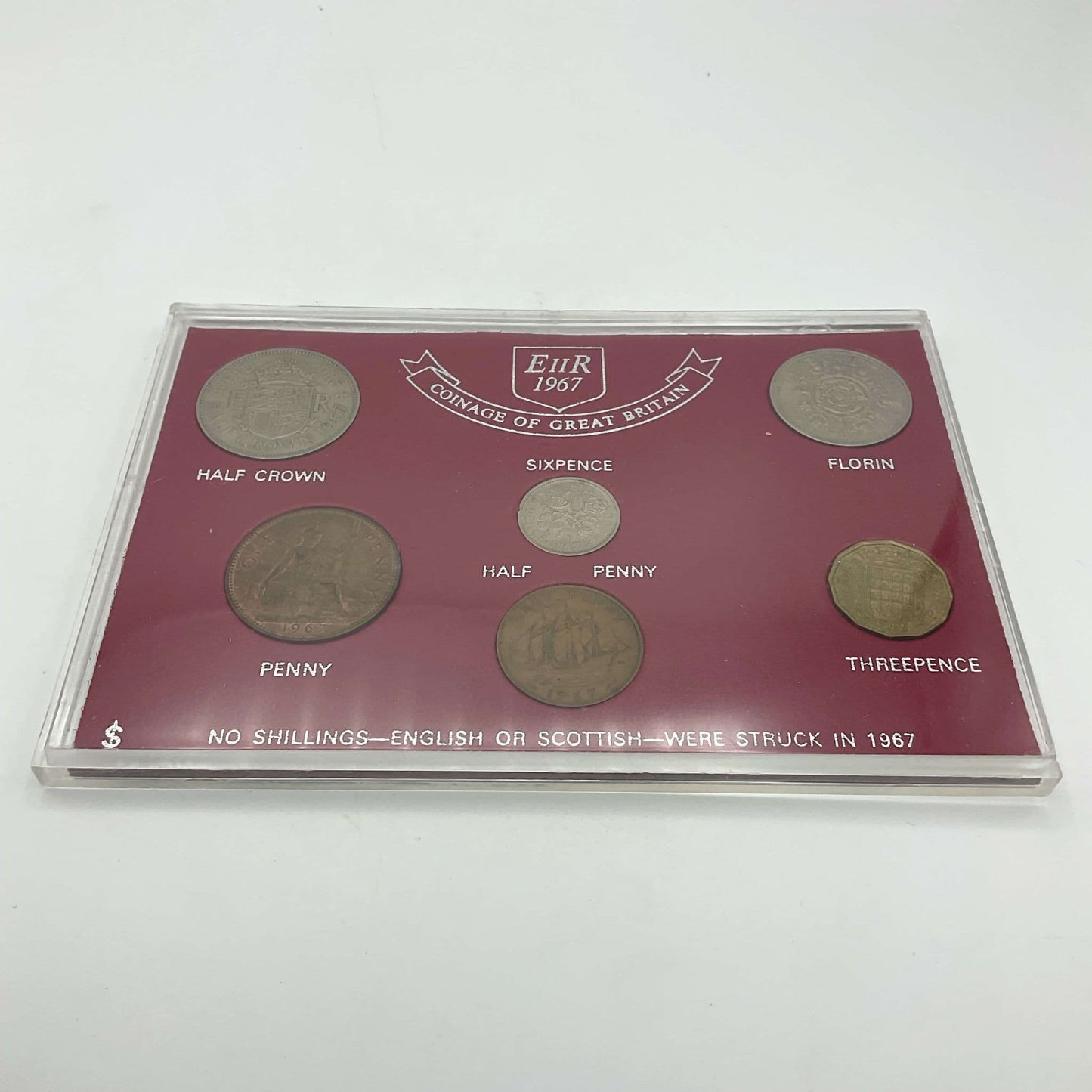 Six pre decimal currency coins in a red case