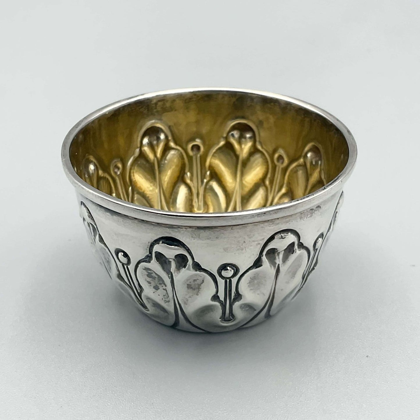 Antique Silver Salt pot with wavy design on outside and gilded interior on white background