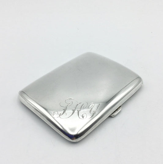 Shiny sterling silver cigarette case with JHY elaborately engraved in the corner on a white background