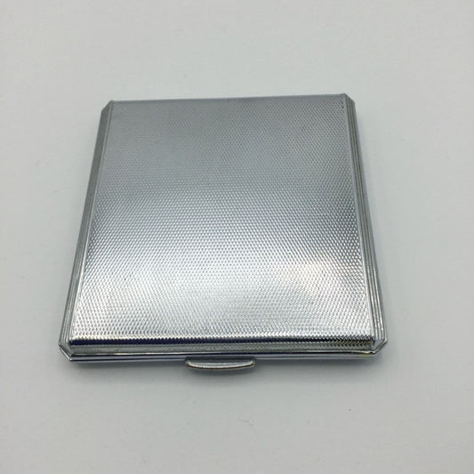 a stunning art deco style silver mirror compact on a white background